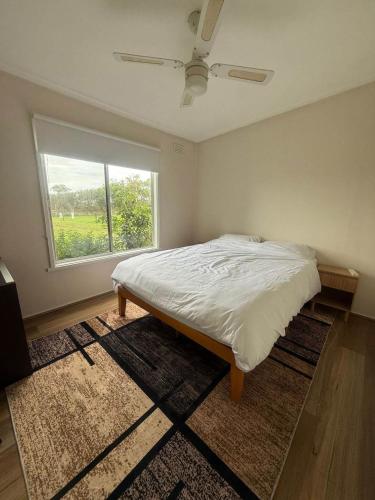 a bedroom with a bed and a large window at Prom Coast Residence in Fish Creek
