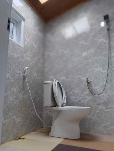 a bathroom with a toilet and a shower at Yus homestay in Bukittinggi