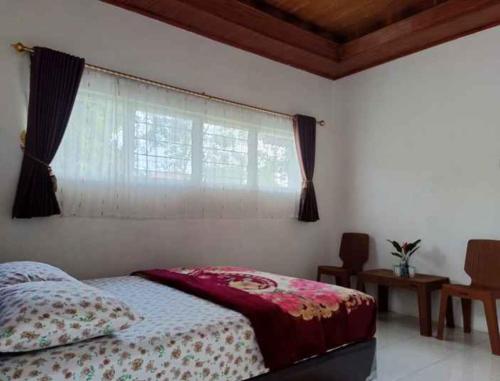 a bedroom with a bed and a window at Yus homestay in Bukittinggi