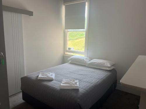 a bedroom with a bed with two towels on it at Branxholm Hotel in Branxholm