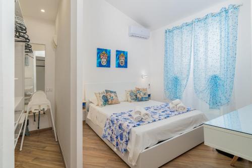a bedroom with a bed with blue curtains at Casa Mare Vecchio in Avola
