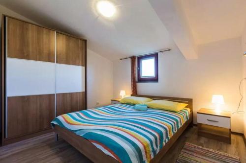 una camera da letto con un grande letto con una coperta colorata di Apartments Marinka a Biograd na Moru