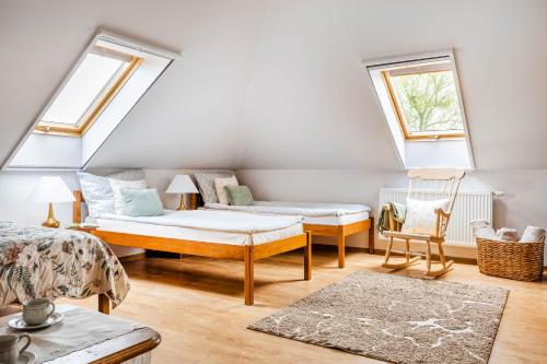 a attic room with a bed and a chair at Dworek Biebrzański in Augustów