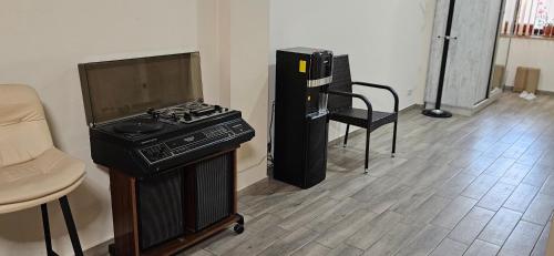 a room with a stove and a tv and a chair at OUR House in Vagharshapat