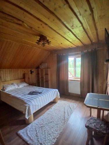 a bedroom with a bed and a wooden ceiling at Садиба Сонячний дім in Pilipets