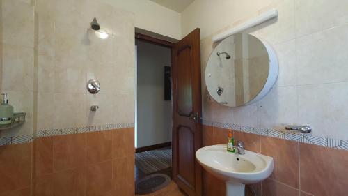 a bathroom with a sink and a mirror at Boudha Breeze Suites 3bhk in Kathmandu