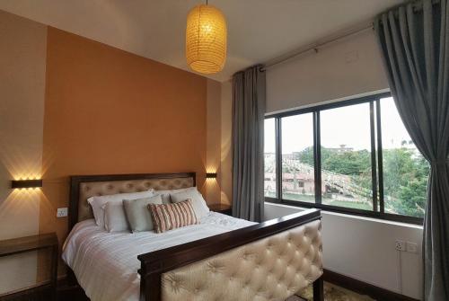 a bedroom with a bed and a large window at Boudha Breeze Suites 3bhk in Kathmandu