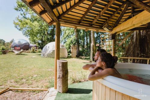 a man and a woman standing in a bath tub at La Bulle au bord de l'eau in Épagne-Épagnette