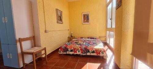 a bedroom with a bed and a chair in it at Casa Ananda in Sorso