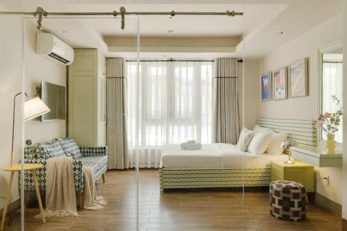 a bedroom with a bed and a couch and a window at LangX Heaven Hotel & Apartment in Danang