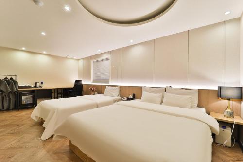 two beds in a hotel room with at Jamsil Tomgi Hotel in Seoul