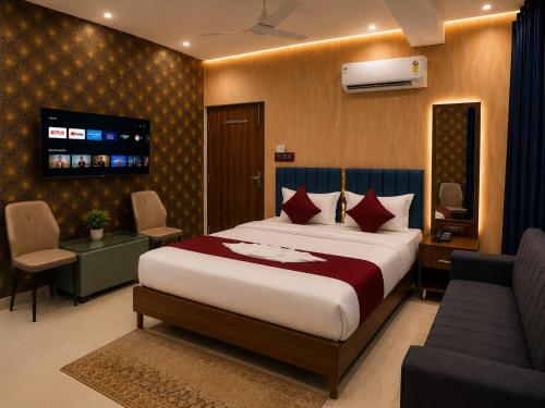 a bedroom with a bed and a tv and a couch at Hotel SS Residency in Patna