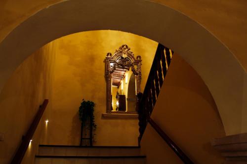 an archway with a mirror and a stair case at Hotel Boutique Casa Don Gustavo, Campeche in Campeche