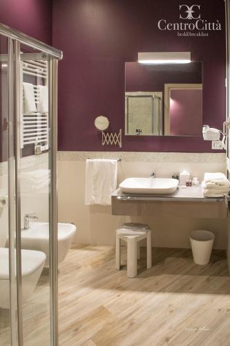 a bathroom with a sink and a toilet and a mirror at Centro Città Luxury B&B in Foggia