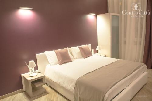 a bedroom with a large white bed and two lamps at Centro Città Luxury B&B in Foggia