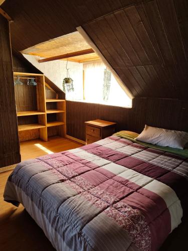 a bedroom with a large bed in a attic at Yanesh Haus habitaciones Oxapampa in San Antonio