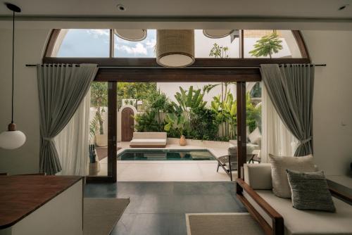 a living room with a large window and a pool at Suasana by AYA in Uluwatu