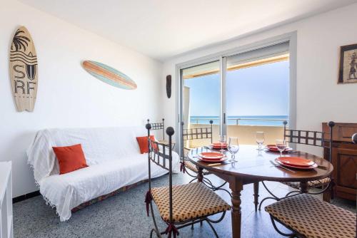 a living room with a table and a bed and a window at Valras'Loc - Evasion Marine in Valras-Plage