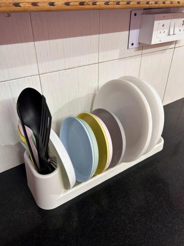 a holder with plates and utensils on a wall at Electrifying Pearl in Bangalore