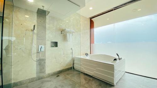 a bathroom with a shower and a sink at Agro Hotel Bintan in Telukbakau