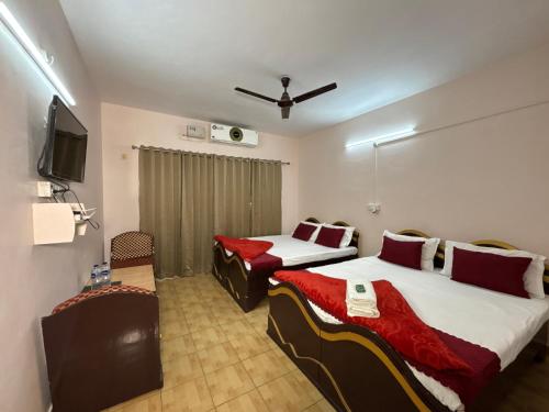 a hotel room with two beds and a flat screen tv at Sheetal Resort and Restaurant in Rudraprayāg