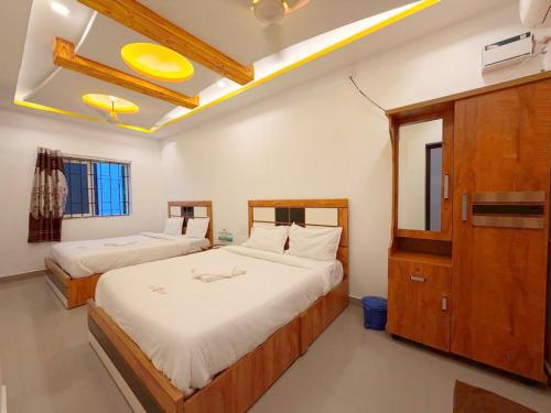 a bedroom with two beds and a dresser in it at EESHA Beach View Stay - Near Temple and Beach in Rāmeswaram