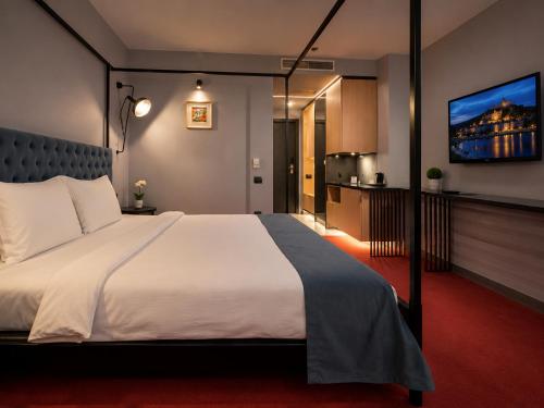 a bedroom with a large bed and a flat screen tv at Vitosha Park Hotel - Free Pool & Gym in Sofia