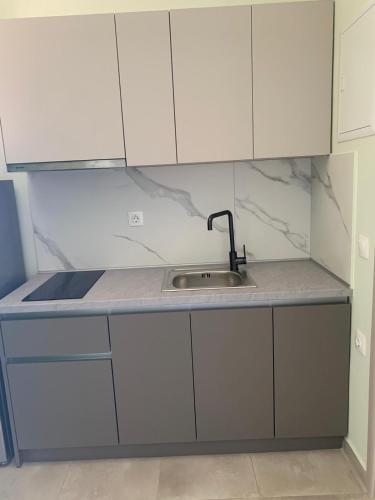 a kitchen with white cabinets and a sink at Resort Finikas in Alexandroupoli