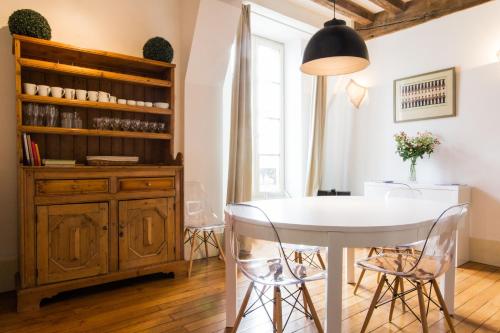 a dining room with a white table and chairs at Les Bons Enfants in Dijon