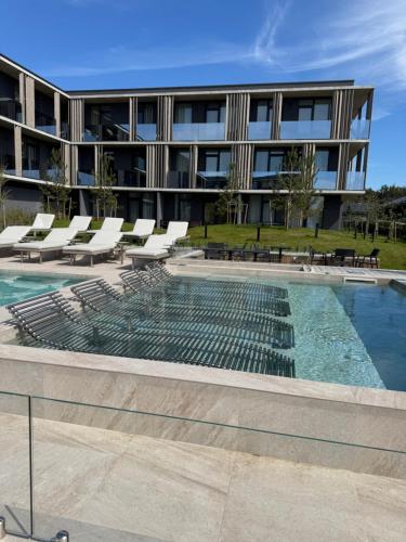 a swimming pool in front of a building at Infinutum Sea Studio in Palanga