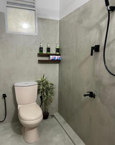 a bathroom with a toilet and a shower at AmoreBay in Mirissa