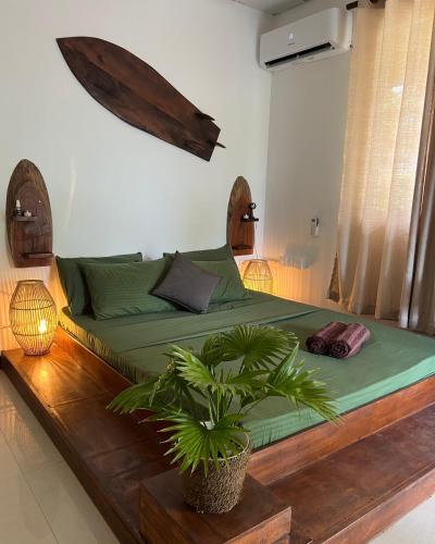 a bedroom with a green bed with a potted plant at AmoreBay in Mirissa