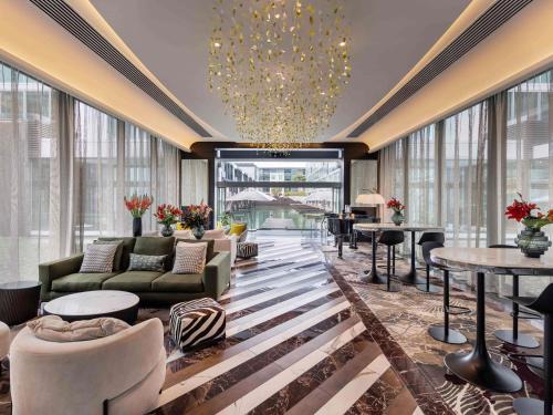 a hotel lobby with couches and tables and windows at Sofitel Auckland Viaduct Harbour in Auckland