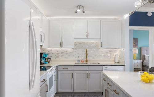 a white kitchen with white cabinets and a sink at Laketown Wharf 809 in Panama City Beach
