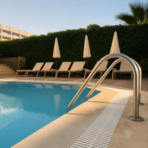 a swimming pool with chairs and umbrellas next to a swimming pool at Ozgur Bey Spa Hotel in Alanya