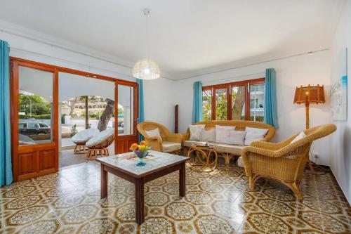 a living room with a couch and chairs and a table at Apartamentos MHM in Cala Ratjada