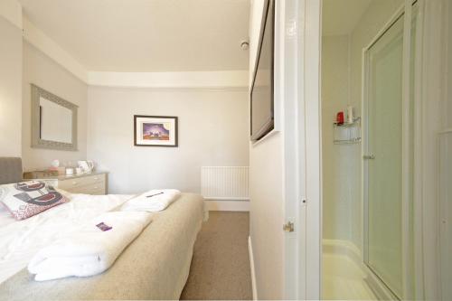 a bedroom with a bed with towels on it at Sunrise Guest House in Bude