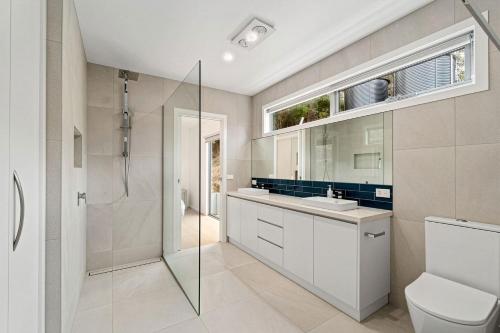 a bathroom with a shower and a toilet and a sink at Gums & Ocean Hideaway at Wye in Wye River