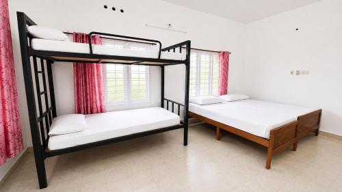 two bunk beds in a room with a window at K Cottage in Varkala