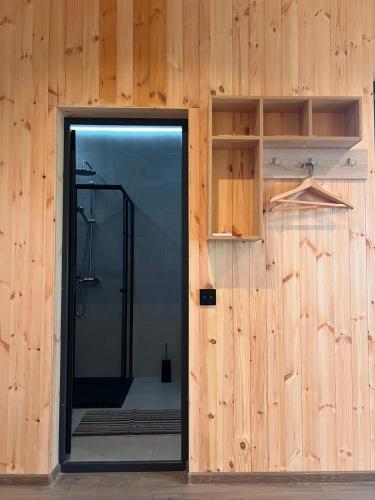 a glass door leading to a shower in a wooden wall at Sevan Resort No5 in Chʼkalovka