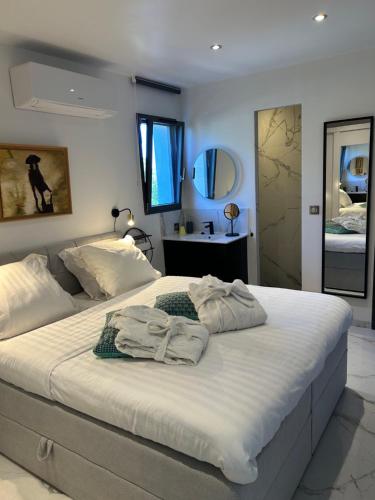 a bedroom with a large white bed with towels on it at VILLA MESSILIA Guest Rooms French Riviera in Saint-Raphaël