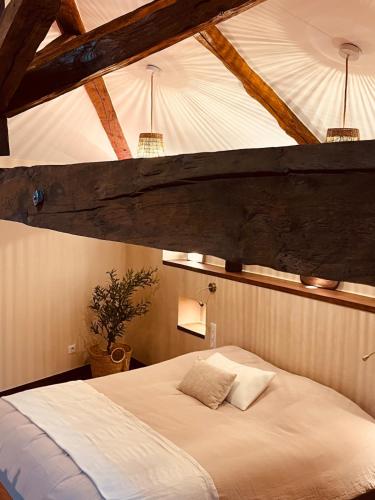a bedroom with a white bed with two pillows at Maison Laroque & Spa in Bellefont-La Rauze