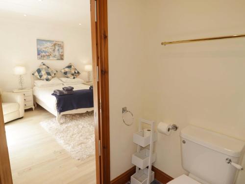 a bathroom with a bed and a toilet in a room at Charlecote House in Saundersfoot