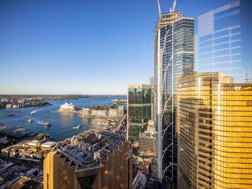 a view of a city with tall buildings and a river at The Sebel Quay West Suites Sydney in Sydney