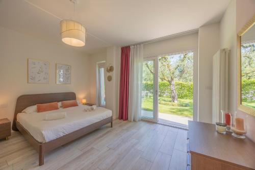 a bedroom with a bed and a large window at Appartamenti Villa Andrea in Garda