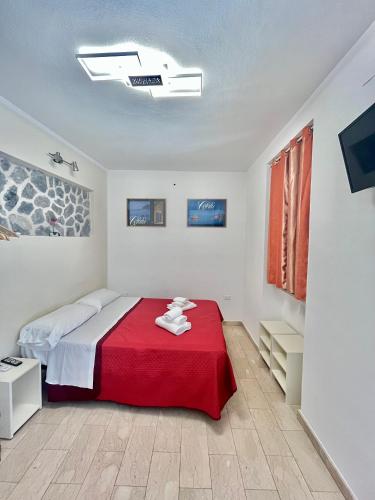 a bedroom with a bed with a red blanket at Studio Osnao Historic City Center in Cefalù