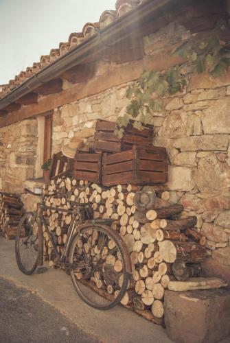 a bike parked next to a wall with logs at La Lagunilla in Laguna del Marquesado