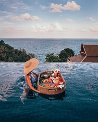 a woman in the water in a boat in the water at Ayara Kamala Resort & Spa in Kamala Beach