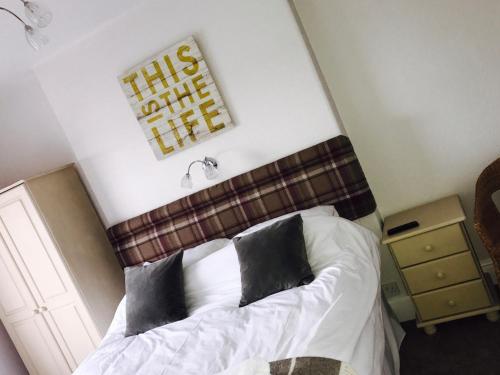 a bedroom with a bed with black and white pillows at Sunrise Guest House in Bude