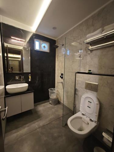 a bathroom with a toilet and a sink and a shower at Hotel Kaashika in Varanasi